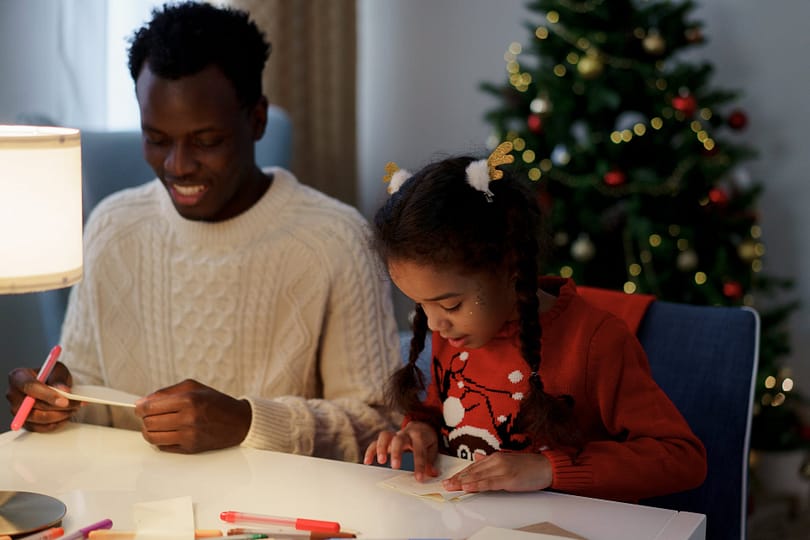 dad and daughter making a christmas letter