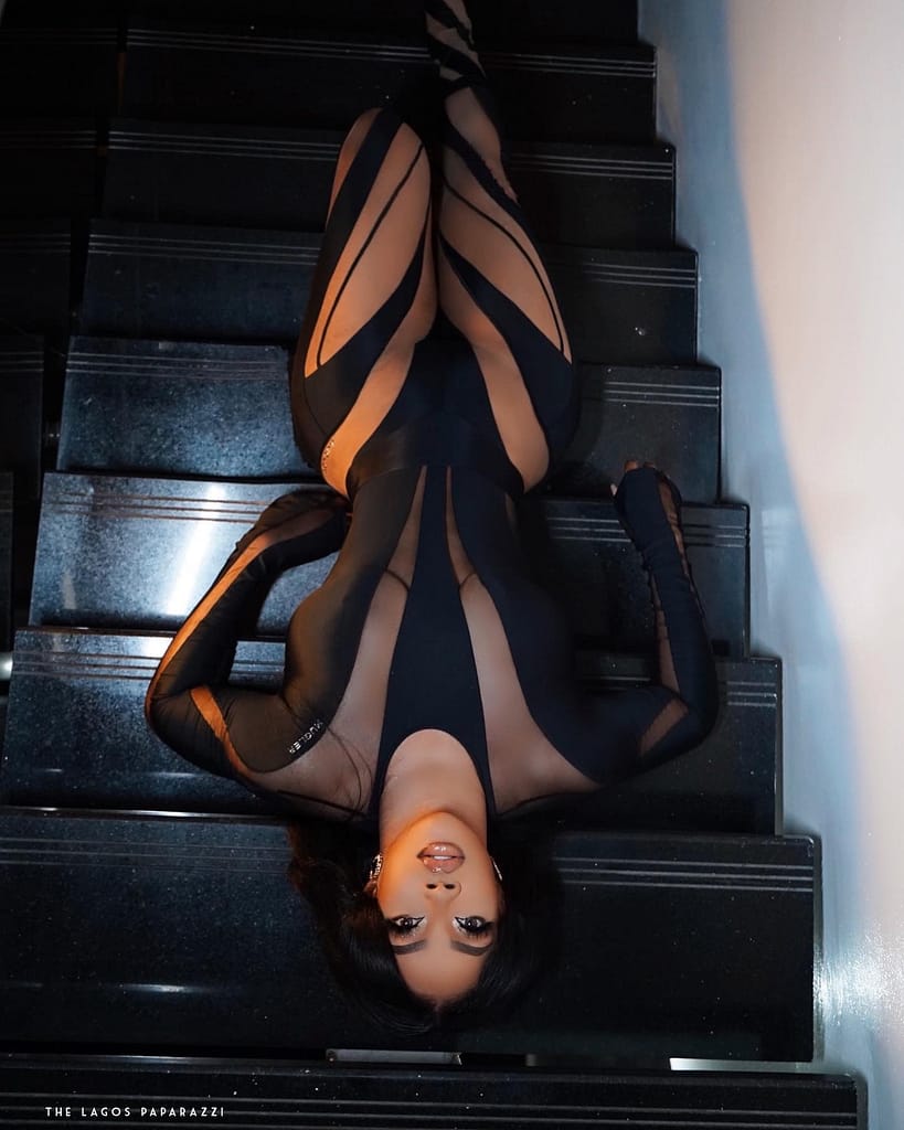 Toke Makinwa in a transparent body jumper laying on a staircase Toke Makinwa in a transparent body jumper laying on a staircase