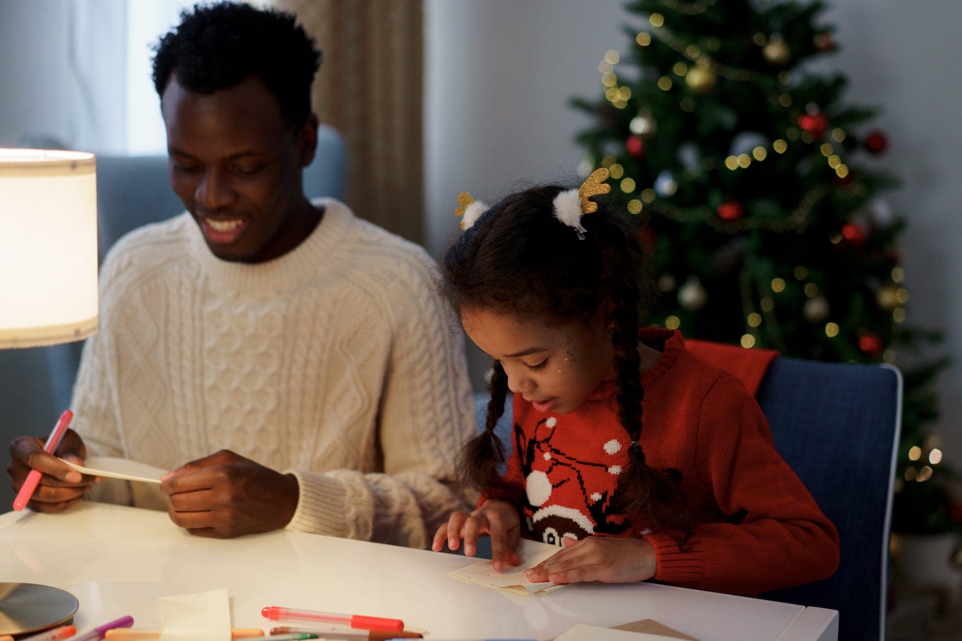 dad and daughter making a christmas letter