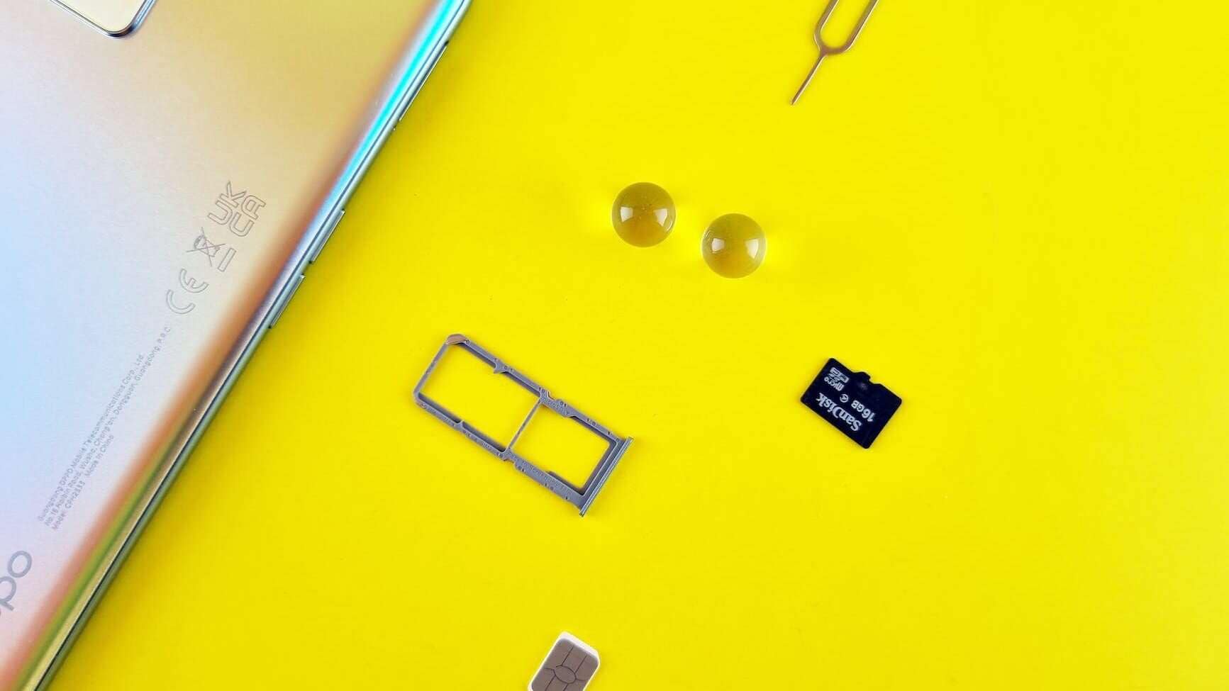 a mobile phone with sim and memory card on yellow surface